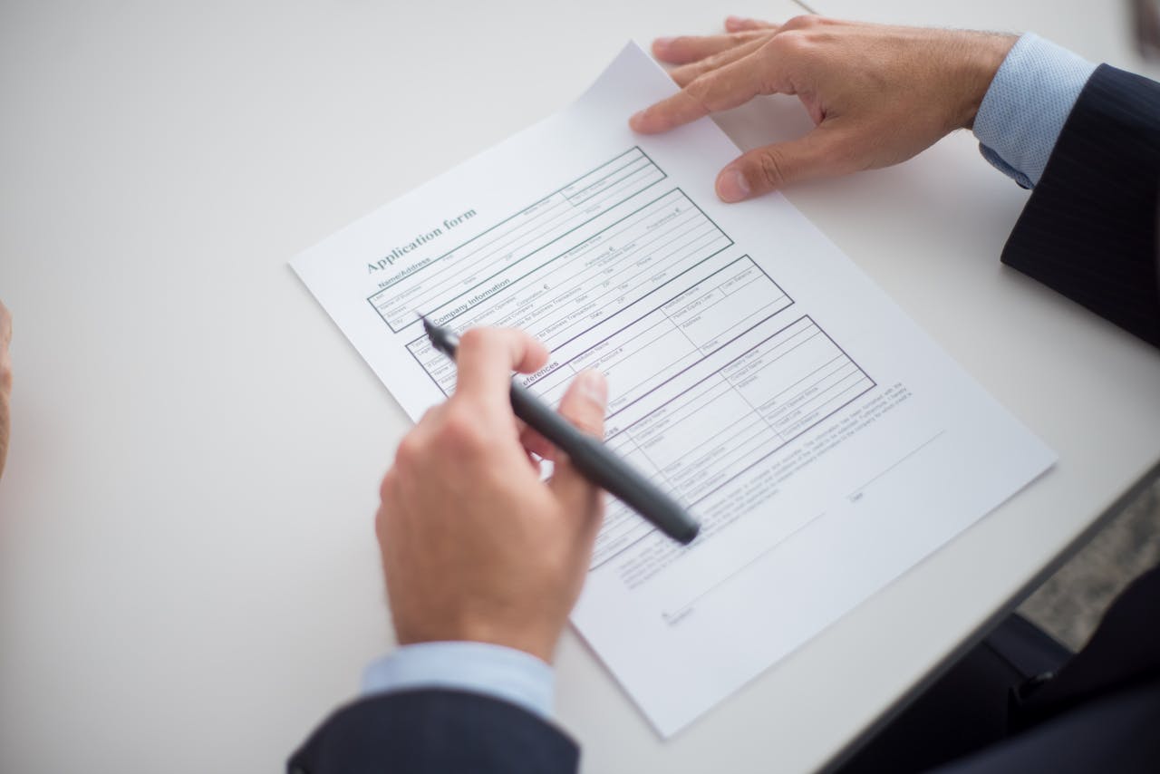 services-bg Close-up of a business professional reviewing an application form at a desk.